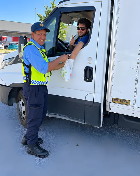 Addetto Kosmos Security in gilet ad alta visibilità accanto alla cabina di un furgone al varco di un polo logistico