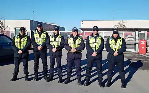 La squadra Kosmos Security in divisa ad alta visibilità nel piazzale di un polo logistico