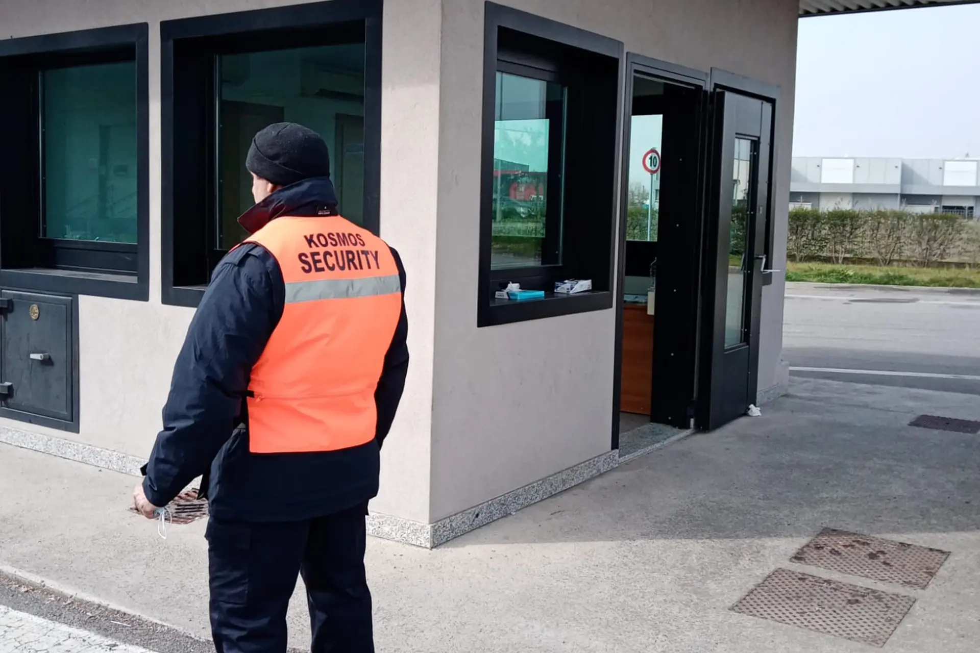 Operatore Kosmos con pettorina arancione davanti a una guardiola